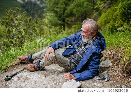 Senior man injured his leg during hike in the mountains. Senior man injured his leg during hike in the mountains. 105923056