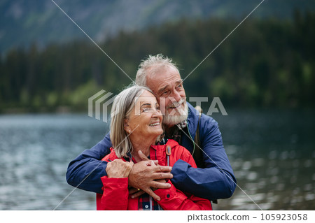 Portrait of beautiful active senior couple hiking together in autumn mountains. 105923058