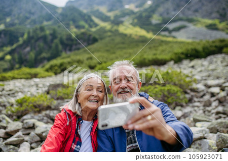 Active senior couple hiking together in autumn mountains. 105923071
