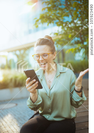 woman worker in green blouse and eyeglasses using smartphone 105923490