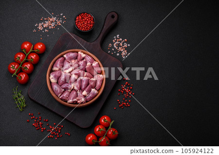 Fresh raw chicken or turkey hearts in a ceramic plate with salt, spices and herbs 105924122