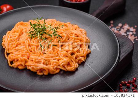 Delicious fresh pasta consisting of thin noodles, red pesto rosso sauce with spices and herbs Delicious fresh pasta consisting of thin noodles, red pesto rosso sauce with spices and herbs 105924171