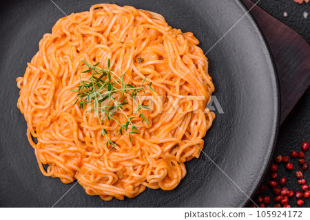 Delicious fresh pasta consisting of thin noodles, red pesto rosso sauce with spices and herbs Delicious fresh pasta consisting of thin noodles, red pesto rosso sauce with spices and herbs 105924172