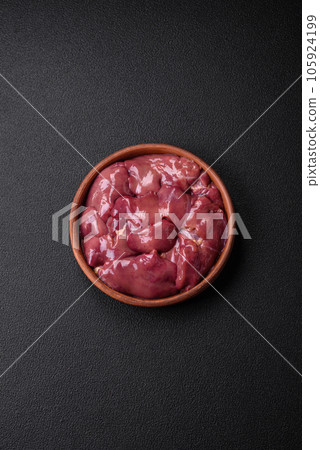 Fresh raw chicken or turkey liver in a ceramic plate with salt, spices and herbs 105924199
