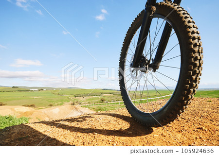 Cycling, sports and closeup of wheel on bicycle for adrenaline on adventure, freedom and speed. Mountain bike, nature view and cyclist for training, exercise and fitness on dirt road, trail or track 105924636