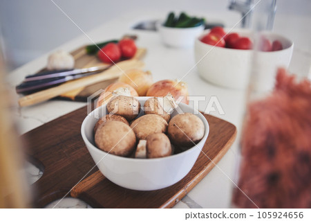 Cooking, food and vegetables on kitchen counter for meal prep, cutting and nutrition on wooden board. Healthy diet, ingredients and closeup of mushrooms in bowl for vegan dinner, lunch and supper Cooking, food and vegetables on kitchen counter for meal prep, cutting and nutrition on wooden board. Healthy diet, ingredients and closeup of mushrooms in bowl for vegan dinner, lunch and supper 105924656