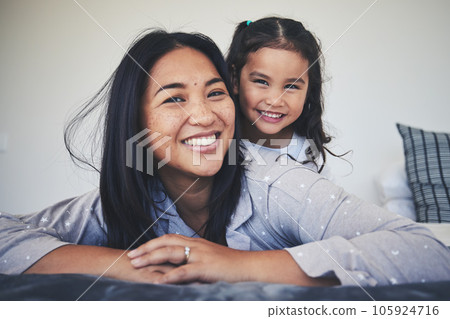 Portrait, mother and daughter in bed at home with love, care and happiness in morning. A young woman and girl child together in a bedroom for fun time, playing and security or relax in a family house 105924716