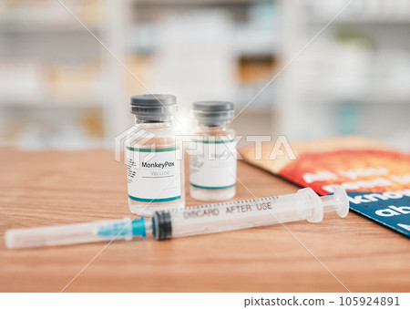 Pharmacy, syringe and vial of vaccine for cure, medication or monkeypox in healthcare on table. Drugs, needle and pharmaceutical product on desk for vaccination, flu shot or equipment at the clinic Pharmacy, syringe and vial of vaccine for cure, medication or monkeypox in healthcare on table. Drugs, needle and pharmaceutical product on desk for vaccination, flu shot or equipment at the clinic 105924891