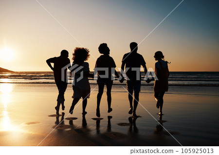 Beach, sunset and back of friends holding hands with freedom, bond and fun on summer vacation. Ocean, silhouette and rear view of people together at the sea for travel, holiday or adventure in Miami Beach, sunset and back of friends holding hands with freedom, bond and fun on summer vacation. Ocean, silhouette and rear view of people together at the sea for travel, holiday or adventure in Miami 105925013