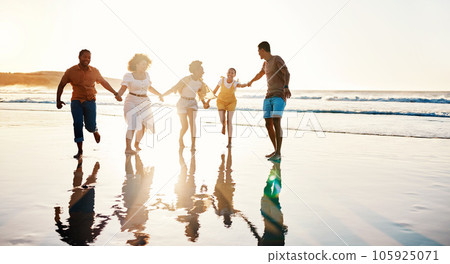 Friends, running and people happy at sunset beach for fun, freedom and travel with care. Diversity, men and women group holding hands in nature with sand, love and happiness on a vacation or holiday 105925071