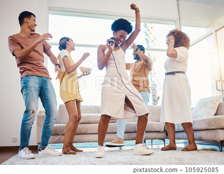 Happy, party and people singing karaoke in the living room with a microphone to music, playlist or radio. Entertainment, diversity and young friends dancing, bonding and having fun together at home. Happy, party and people singing karaoke in the living room with a microphone to music, playlist or radio. Entertainment, diversity and young friends dancing, bonding and having fun together at home. 105925085