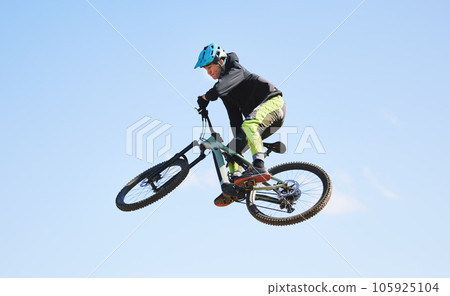 Bicycle, man and jump in blue sky for competition, freedom and adventure with mockup space. Athlete, sports and bike in air for action, cardio race and courage for stunt performance, power or contest 105925104