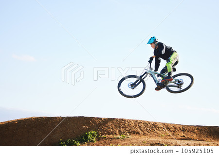 Cycling, sports and man jump with bicycle for adrenaline on adventure, freedom and in air for speed. Mountain bike, tricks and cyclist for training, exercise and fitness on dirt road, trail and track 105925105