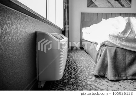 Wall mounted air conditioner unit in a room.  105926138