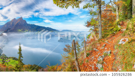 Breathtaking autumn view of Stansstad city and Lucerne lake with mountaines and fog. 105926286