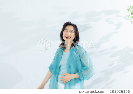 一名身穿淺藍色襯衫的中年婦女 一名身穿淺藍色襯衫的中年婦女 105926396