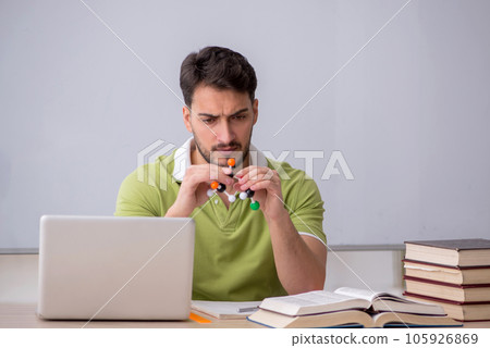 Young male student physicist sitting in the classroom 105926869