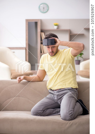Young man enjoying virtual glasses at home 105926907