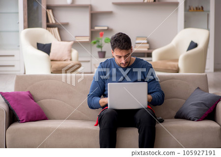 Young male freelancer working from home during pandemic 105927191
