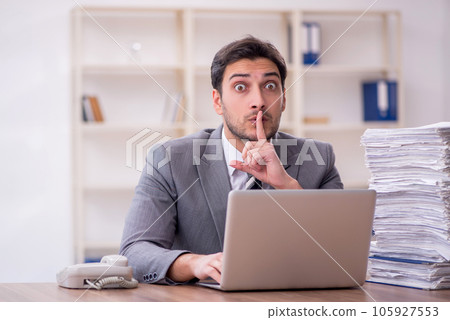 Young male employee and too much work in the office 105927553