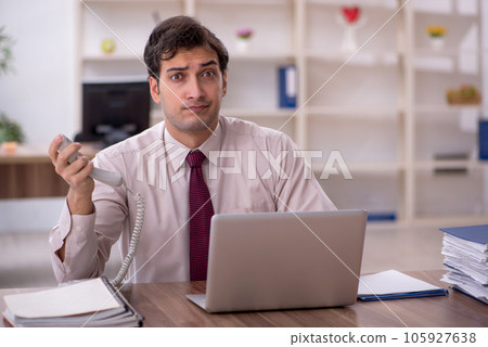 Young male employee and too much work in the office 105927638