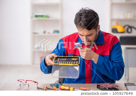 Young male repairman repairing computer 105927649