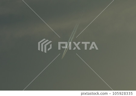 An airplane cloud extending into the blue sky 105928335