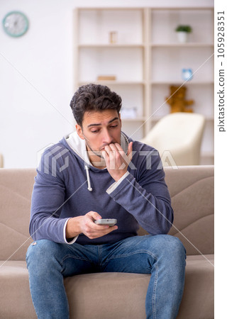 Young man watching tv at home 105928351