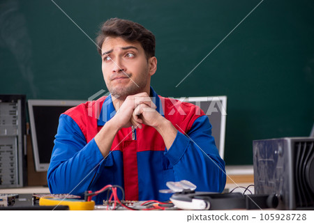 Young male repairman repairing computers in the classroom 105928728