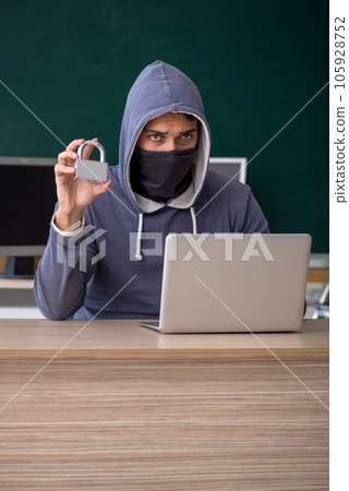 Young male hacker sitting in the classroom Young male hacker sitting in the classroom 105928752