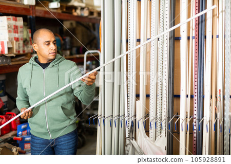 Man buys plastic corners for repair in hardware store 105928891