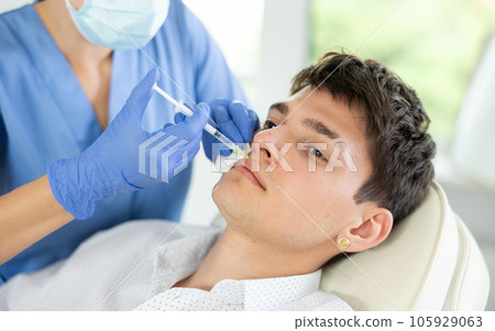 Young man having face care by means of injection in aesthetic clinic 105929063