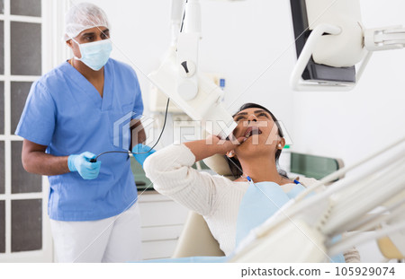 Dentist makes x-ray of patients teeth Dentist makes x-ray of patients teeth 105929074