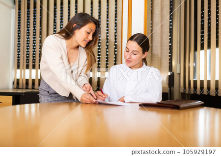 Woman signing apply for job agreement sitting at office 105929197