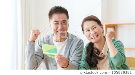 A senior couple holding a passbook and doing a guts pose A senior couple holding a passbook and doing a guts pose 105929391