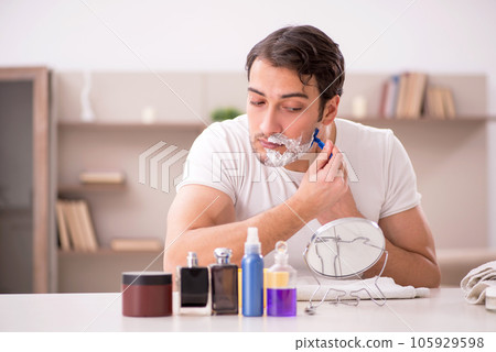 Young man shaving face at home Young man shaving face at home 105929598