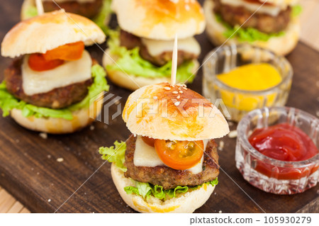 Ready to serve mini hamburgers. Step by step preparation of mini burgers. Homemade mini burgers for children or appetizers. Small hamburgers. 105930279