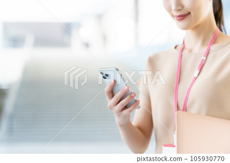 Young female engineer looking at a smartphone Young female engineer looking at a smartphone 105930770