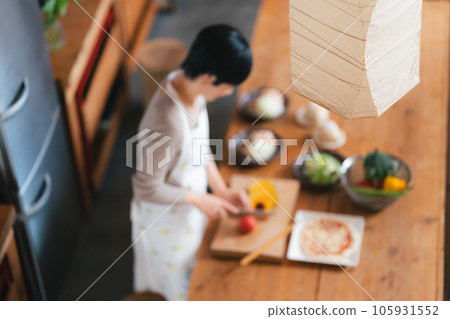 A woman in her 50s cooking in the kitchen A woman in her 50s cooking in the kitchen 105931552