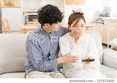 Young couple crying while watching TV/movie Young couple crying while watching TV/movie 105932600