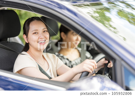 Image of two women driving a car and going on a trip in a refreshing summer | Drive image 105932806