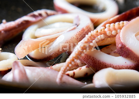 煎鍋裡煎魷魚(煮魷魚)的烹飪場景特寫。 煎鍋裡煎魷魚(煮魷魚)的烹飪場景特寫。 105932885