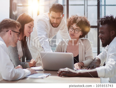 Employees working at computer together, discussing content Employees working at computer together, discussing content 105933743