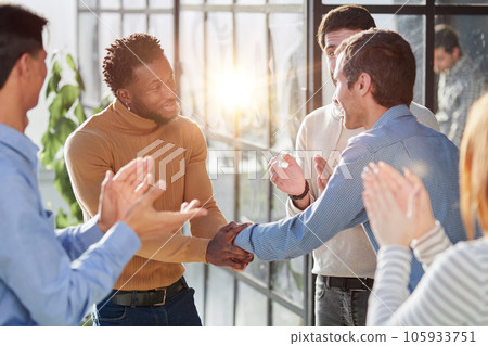 Smiling multiethnic friend getting acquainted in office corridor 105933751