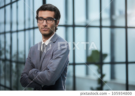 Dedicated to his business. Shot businessman standing with his arms crossed crossed in an office at work. 105934800