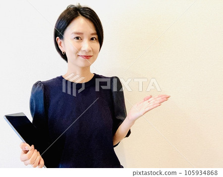 一位女士單手拿著平板電腦進行解釋 105934868