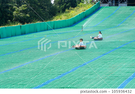 亞洲小學生暑假期間在草坪滑梯上玩耍 亞洲小學生暑假期間在草坪滑梯上玩耍 105936432