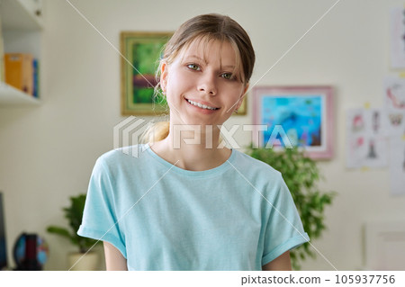 Close up portrait of preteen girl looking at camera inside room Close up portrait of preteen girl looking at camera inside room 105937756