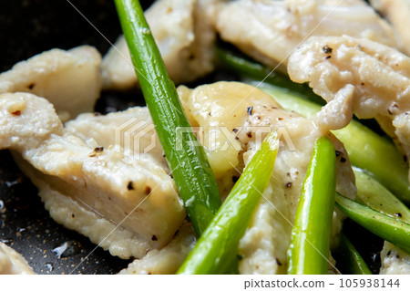 A close-up of a cooking scene in which chicken cartilage (yagen cartilage) and garlic sprouts are fried in a frying pan. 105938144