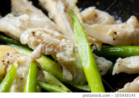 A close-up of a cooking scene in which chicken cartilage (yagen cartilage) and garlic sprouts are fried in a frying pan. 105938145